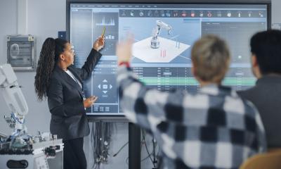 Professor teaching students about robotic arm